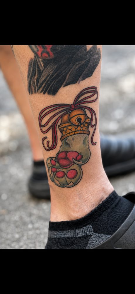 Bold beast paw with crown and bell, heavy black linework
