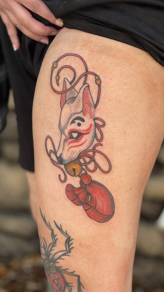 Japanese kitsune fox mask in red and white with bell and tassel