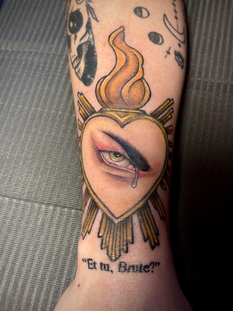 Neo-traditional flaming sacred heart with golden rays and a realistic crying eye